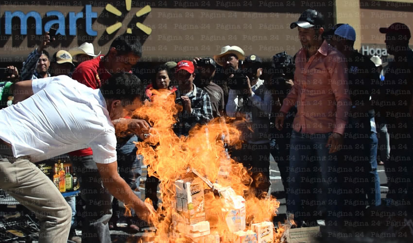 Afuera del Walmart de 16 de Septiembre, en el centro de la ciudad, cientos de productores de leche protestaron contra la falta de apoyo del gobierno estatal y federal; compraron lácteos y los apilaron para prenderles fuego, como forma de manifestación/Fotos: Rogelio Castro