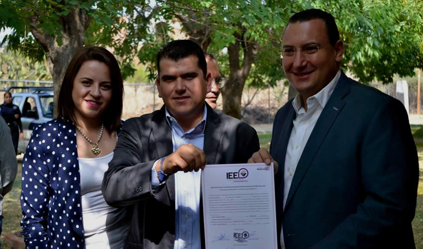 Adán Valdivia López (centro) muestra su constancia de presidente municipal electo