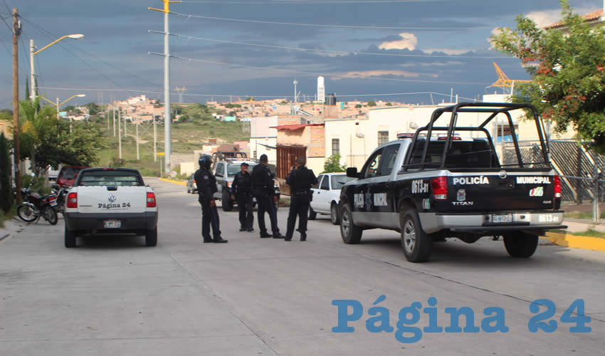 Policías aguardan afuera de la casa donde se escondieron dos robacoches, los cuales previamente habían atacado a un uniformado, logrando quitarle su pistola de cargo para intentar dispararle