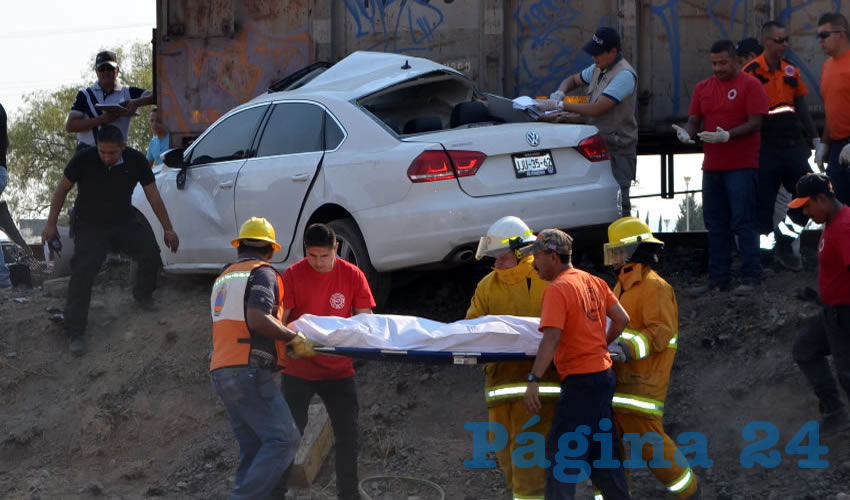 Momento en que los socorristas extraen los cuerpos del destrozado autom&oacute;vil