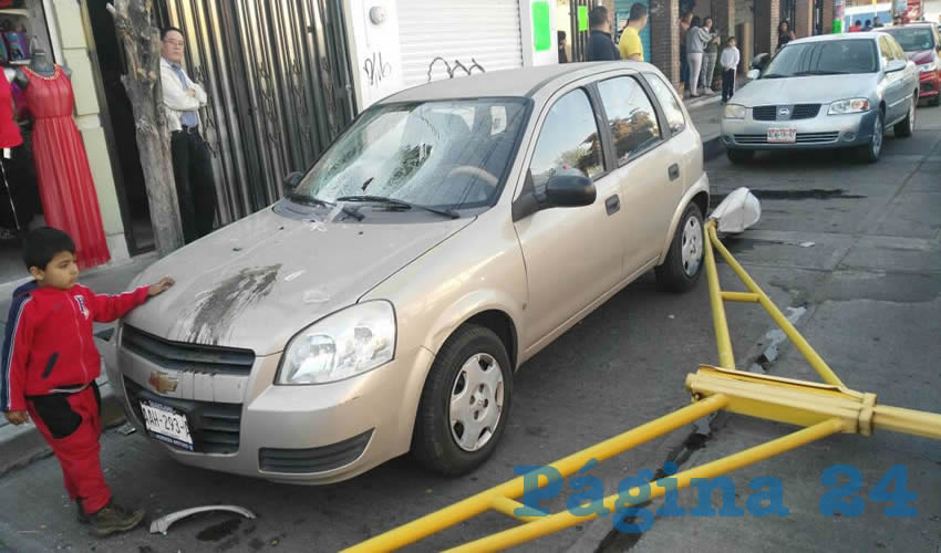Este vehículo estacionado sufrió varios daños al caer el arbotante