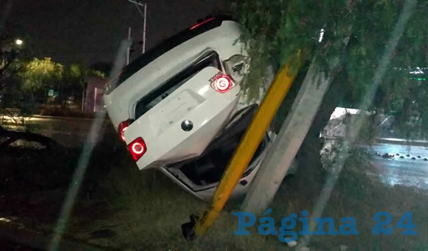 El carro Volkswagen Bora blanco quedó destrozado tras volcarse y chocar contra dos árboles y dos postes