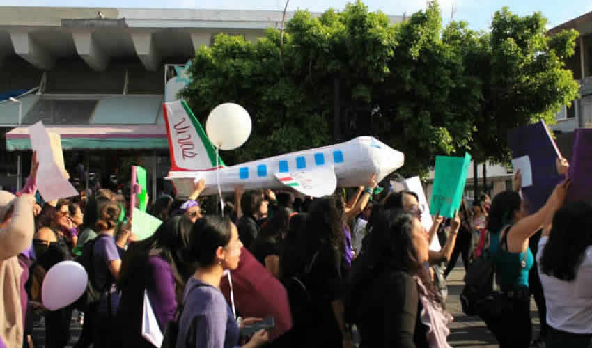 “Un avión a escala de papel periódico. Al frente lleva un letrero ‘Es por todas’, con la total intención de llamar la atención del público como lo hace la rifa del avión presidencial en toda la nación mexicana