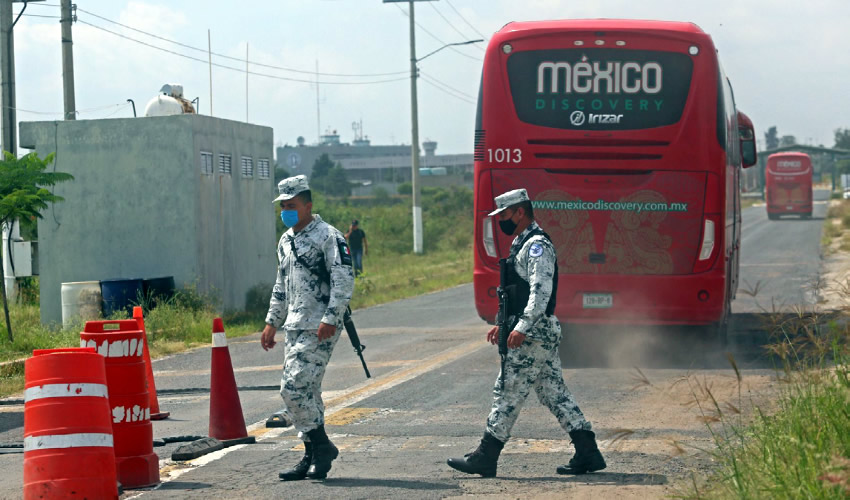 Dos elementos de la Guardia Nacional dan acceso a camiones de servicio turístico que trasladan elementos federales al Centro Federal de Readaptación Social Número 2 Occidente.