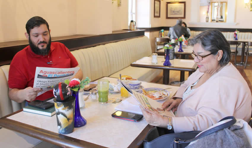 Grupo de personas desayunando.